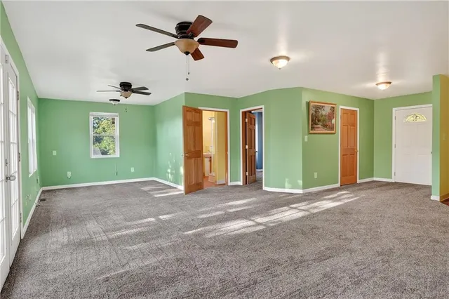 a view of a livingroom with a ceiling fan and window