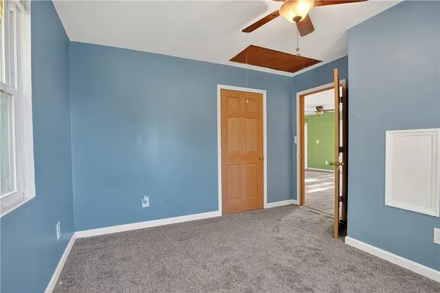 an empty room with closet and a chandelier fan