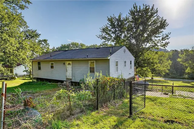 a view of a backyard with table and chairs and a large tree