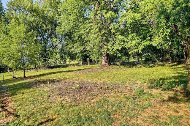 a view of a green field with wooden fence