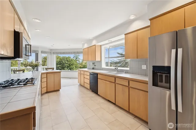 a kitchen with stainless steel appliances a refrigerator sink and stove