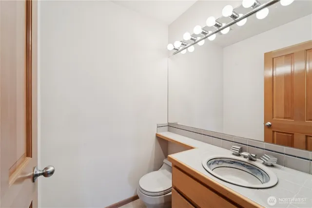 a bathroom with a granite countertop sink a toilet and a mirror