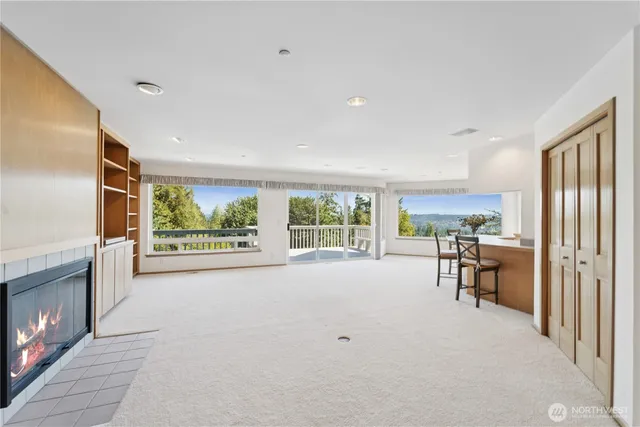 a view of an empty room with a fireplace and a large window