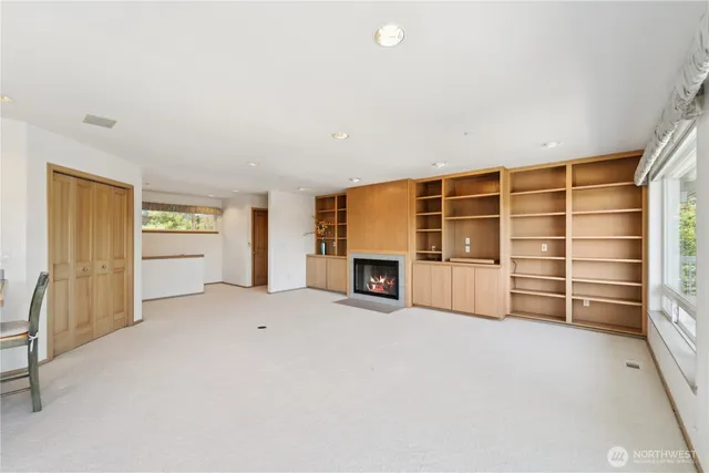 an empty room with a fireplace and cabinet
