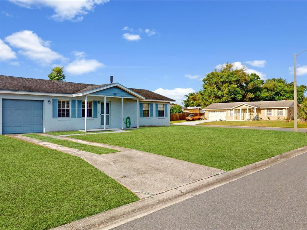 98 Pinata Court Kissimmee, FL 34743 - Photo 2 of 13 a front view of a house with a yard table and chairs
