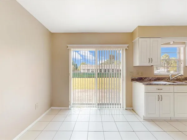 a view of a kitchen with white cabinets and a window