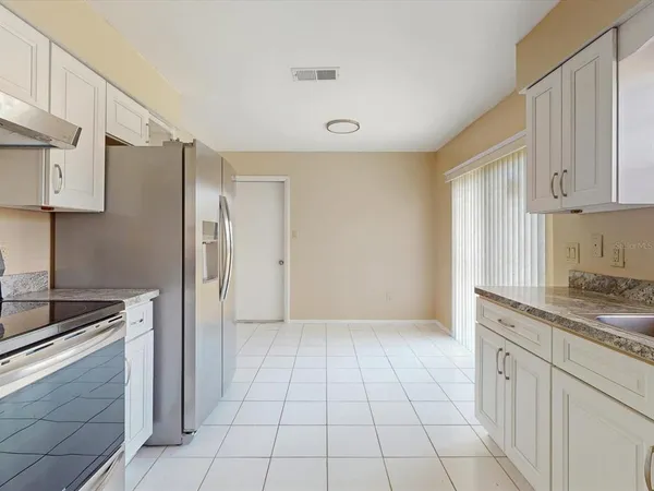 a kitchen with a refrigerator sink and cabinets