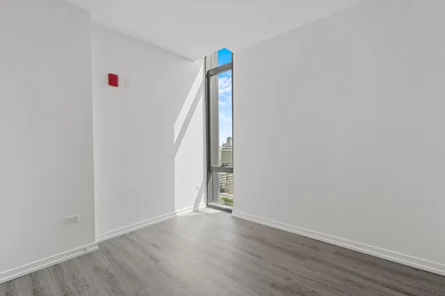 a view of an empty room with wooden floor