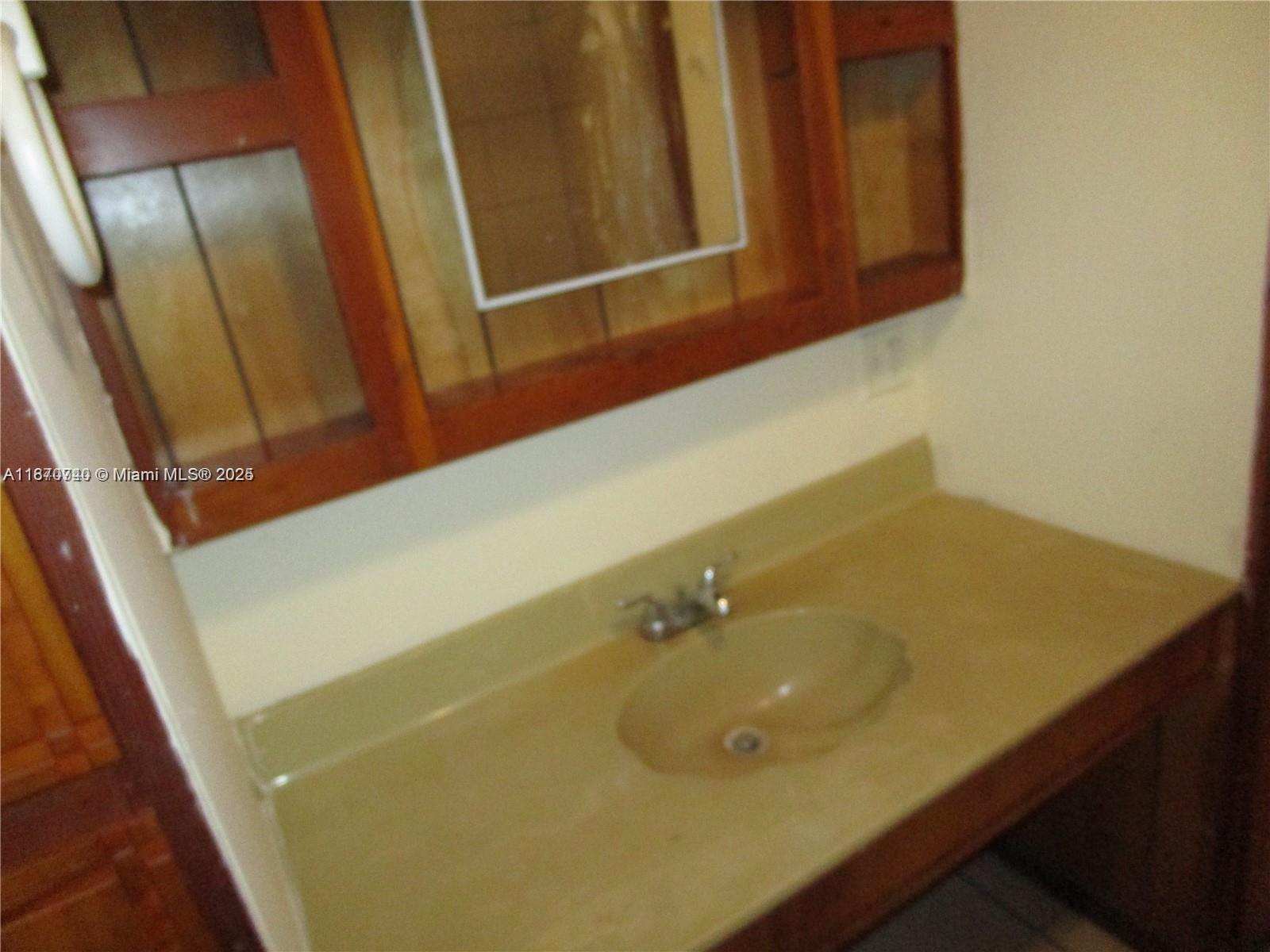 349 Cypress Avenue Pahokee, FL 33476 - Photo 13 of 15 a bathroom with a sink and a mirror