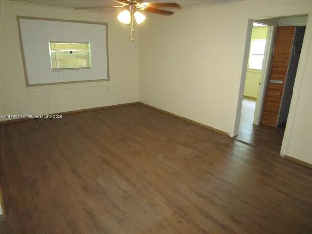an empty room with wooden floor and door
