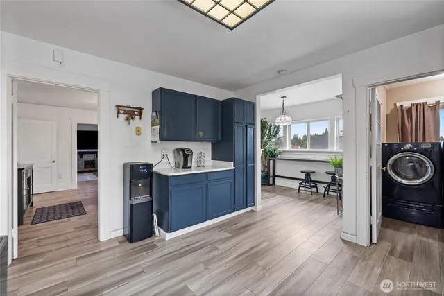 a kitchen with stainless steel appliances a stove a sink a refrigerator cabinets and wooden floor