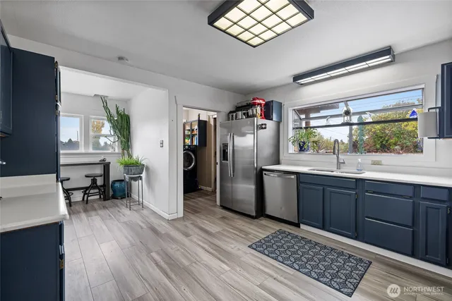 a kitchen with stainless steel appliances kitchen island granite countertop a refrigerator and a sink