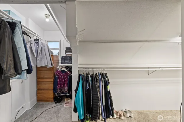 a view of walk in closet with clothes and shoes