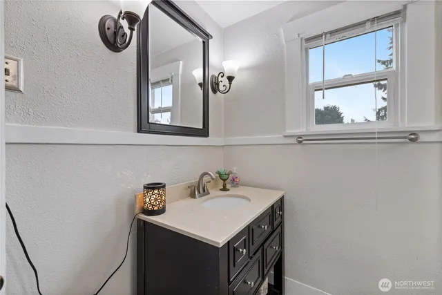 a bathroom with a tub a mirror and a shower