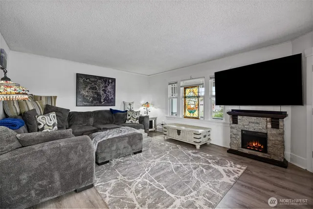 a living room with furniture a flat screen tv and a fireplace
