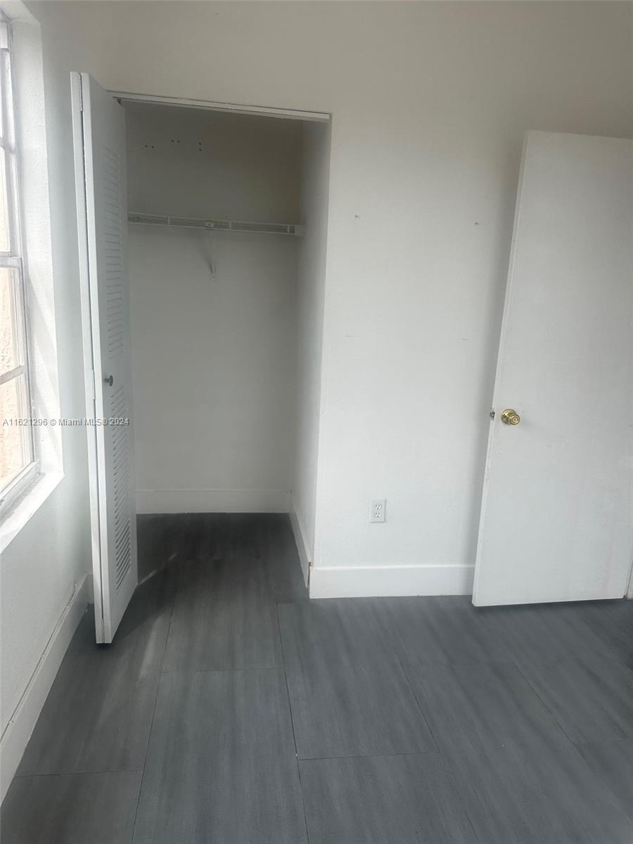 2961 Southwest 5th Street, Unit 15 Miami, FL 33135 - Photo 2 of 4 an empty room with wooden floor and windows