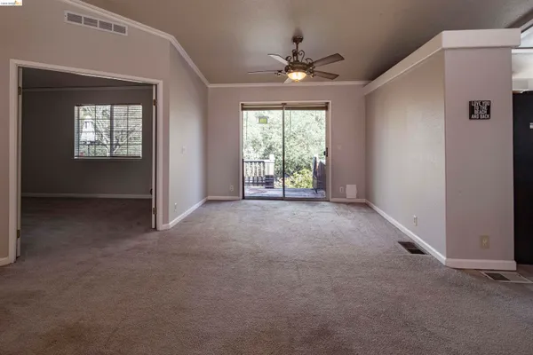 a view of a livingroom with a ceiling fan and window