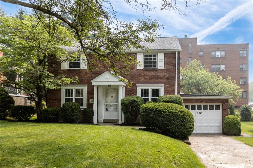 a front view of a house with a garden