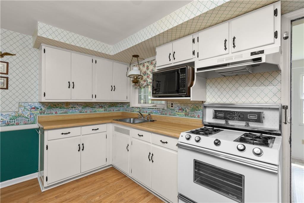 442 Serrano Avenue Pittsburgh, PA 15228 - Photo 12 of 31 a kitchen with cabinets stainless steel appliances and wooden floor