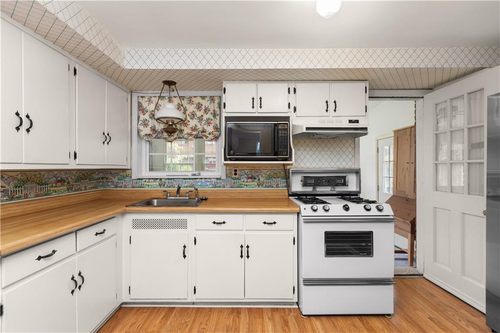 442 Serrano Avenue Pittsburgh, PA 15228 - Photo 9 of 31 a kitchen with stainless steel appliances a white stove top oven cabinets and a window