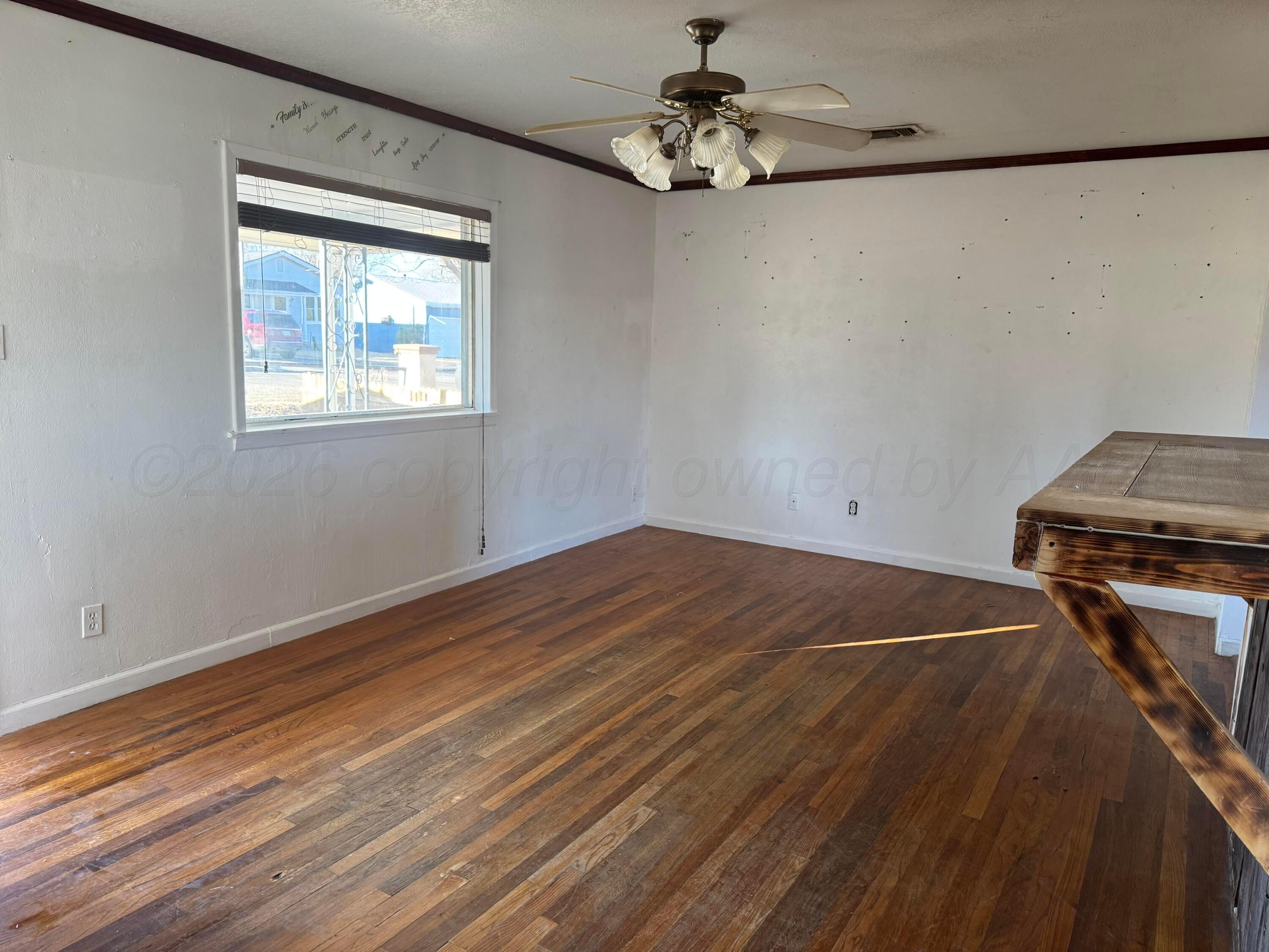 419 East Cheyenne Avenue Canadian, TX 79014 - Photo 2 of 7 a view of a room with wooden floor and chandelier