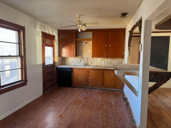 a kitchen with stainless steel appliances granite countertop a sink a stove and a wooden floors