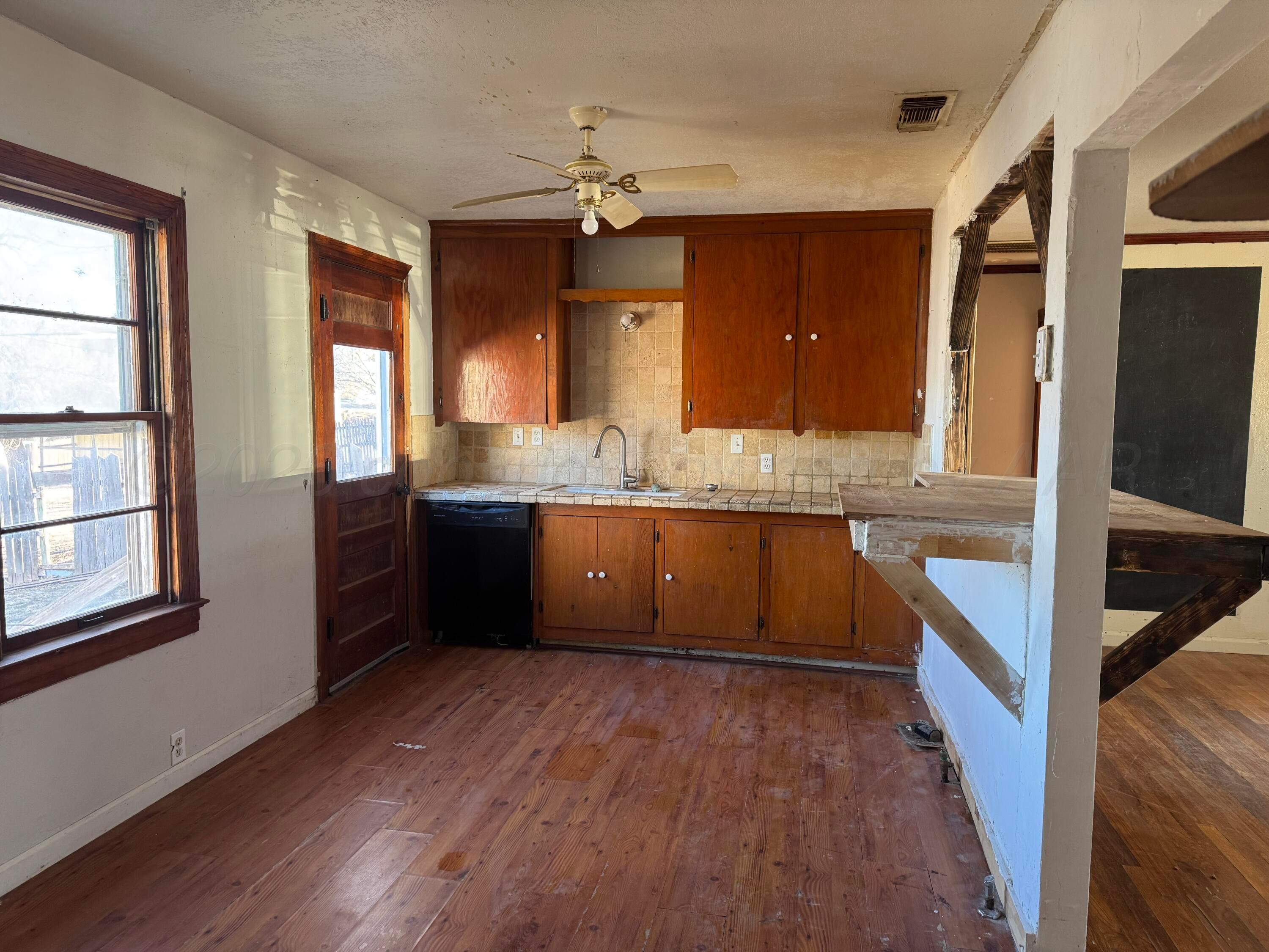 419 East Cheyenne Avenue Canadian, TX 79014 - Photo 6 of 7 a kitchen with stainless steel appliances granite countertop a sink a stove and a wooden floors