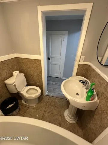 a bathroom with a toilet a sink and mirror