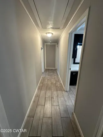 a view of hallway with wooden floor