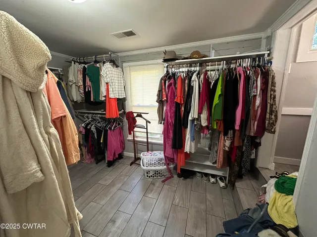 a view of walk in closet with clothes