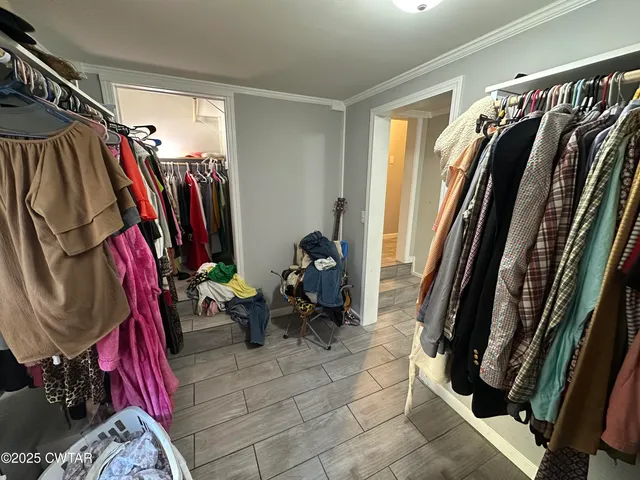a view of walk in closet with clothes and shoes