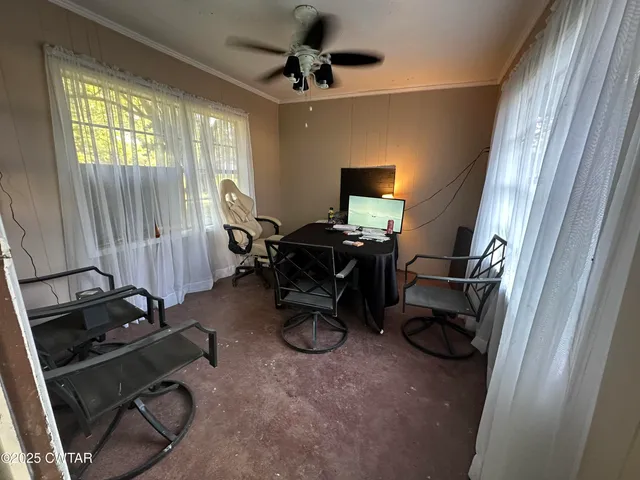 a view of a workspace with furniture and a window