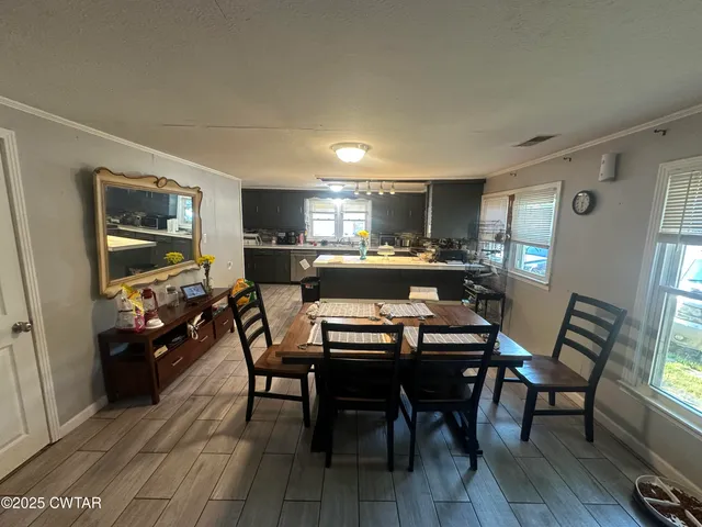 a kitchen with a dining table chairs and refrigerator