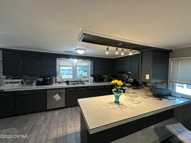 a kitchen with counter top space a sink and appliances