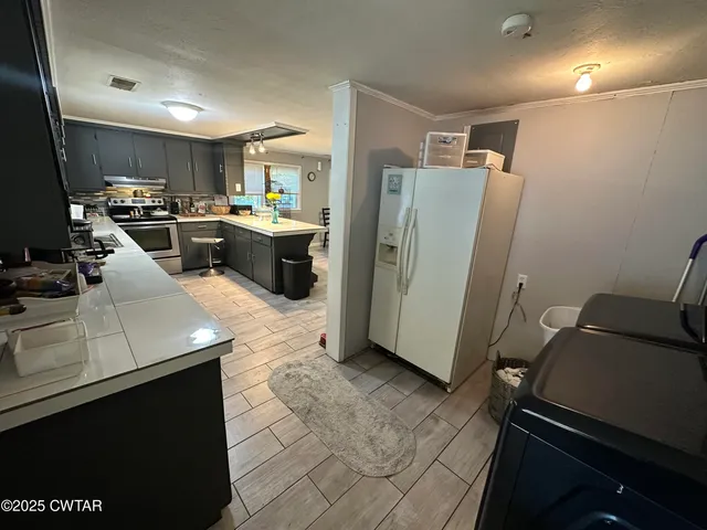 a kitchen with refrigerator and cabinets