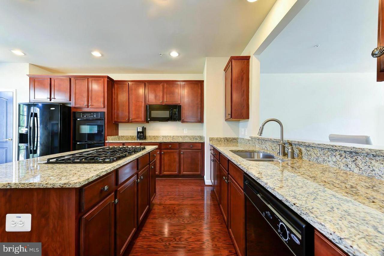 8017 Sport View Road Landover, MD 20785 - Photo 11 of 21 a kitchen with stainless steel appliances granite countertop wooden cabinets sink and stove