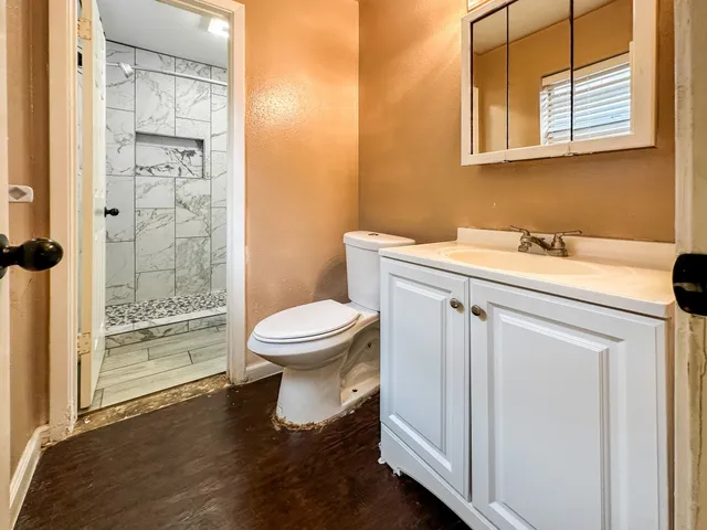 a bathroom with a sink a toilet and shower