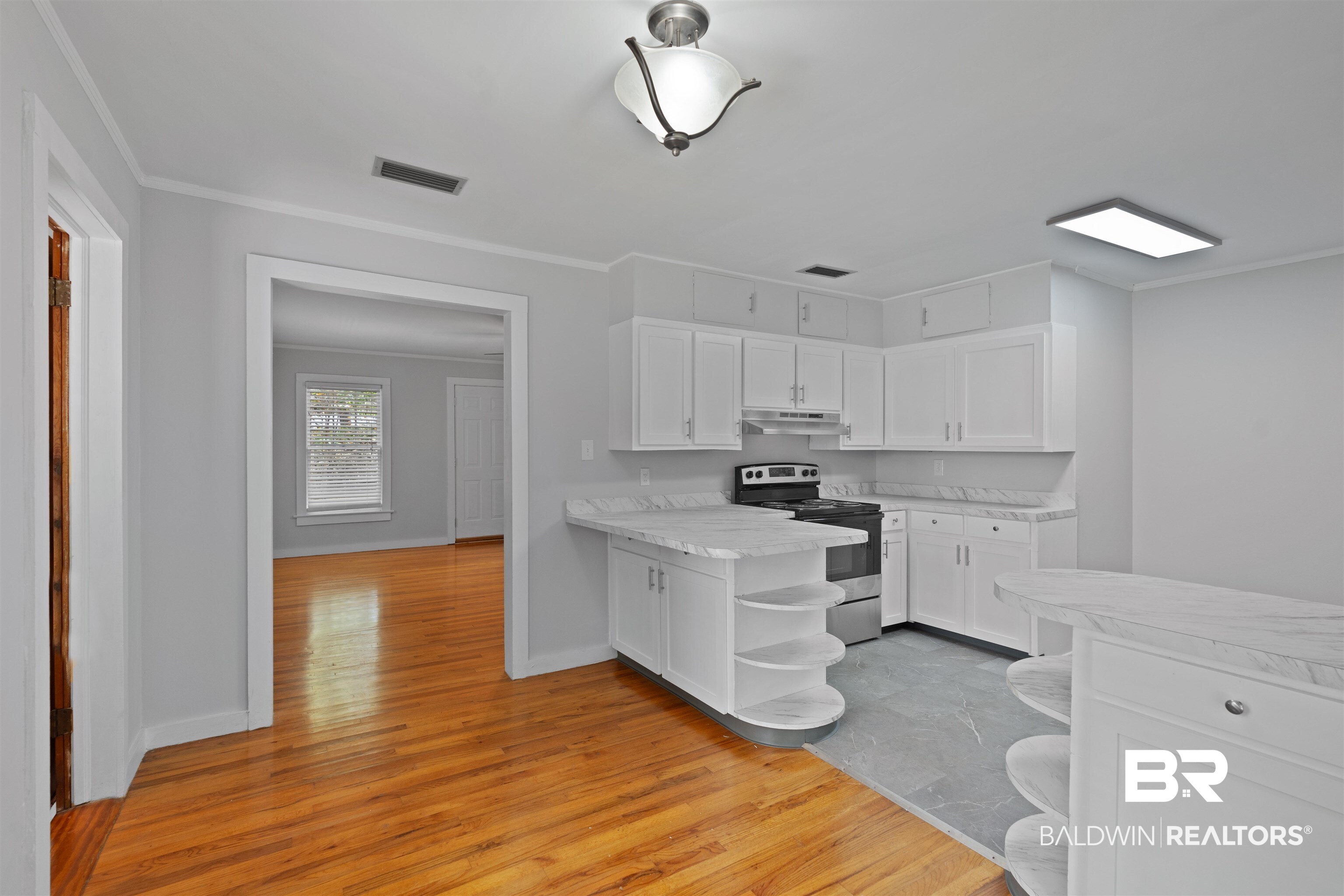 2126 Barron Place Mobile, AL 36605 - Photo 10 of 33 Kitchen with light hardwood / wood-style floors, white cabinets, stainless steel electric range oven, and crown molding