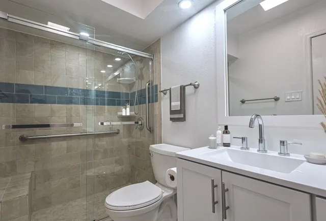 a bathroom with a sink a toilet and shower