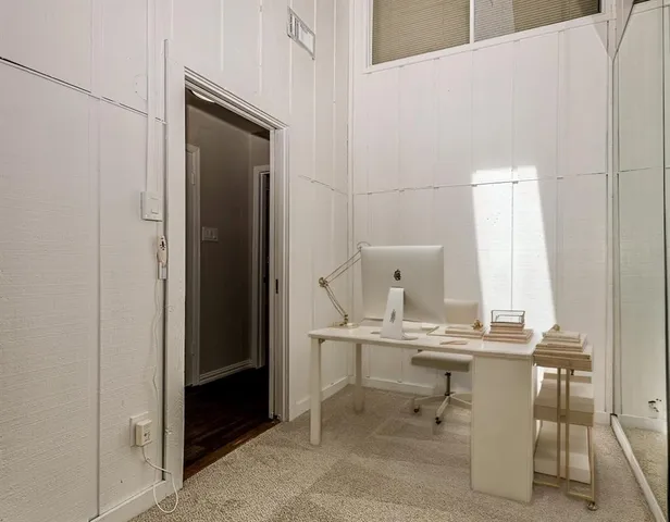 a view of a bedroom with a furniture and mirror