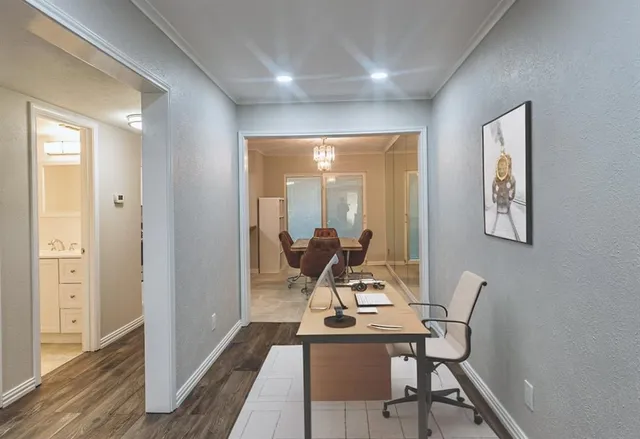 a view of a workspace with furniture and wooden floor