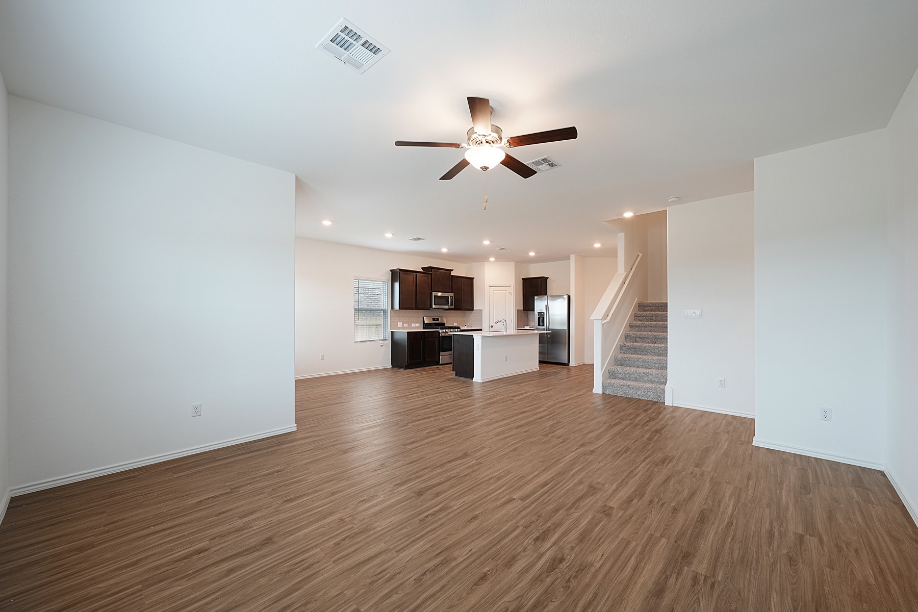 932 Mallow Road Leander, TX 78641 - Photo 23 of 34 An open concept living space features a modern kitchen and inviting wood flooring.