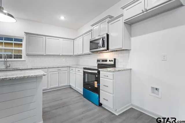 a kitchen with stainless steel appliances granite countertop a stove and a sink