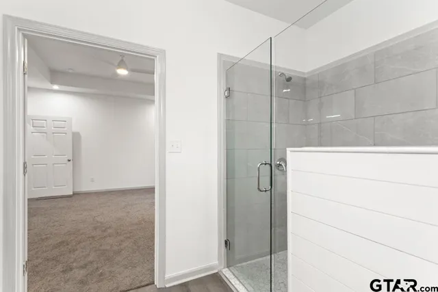 a bathroom with a shower and a glass door