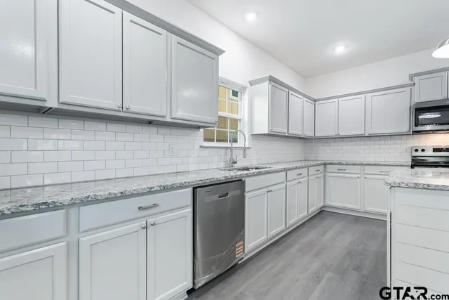 a kitchen with granite countertop white cabinets and white appliances