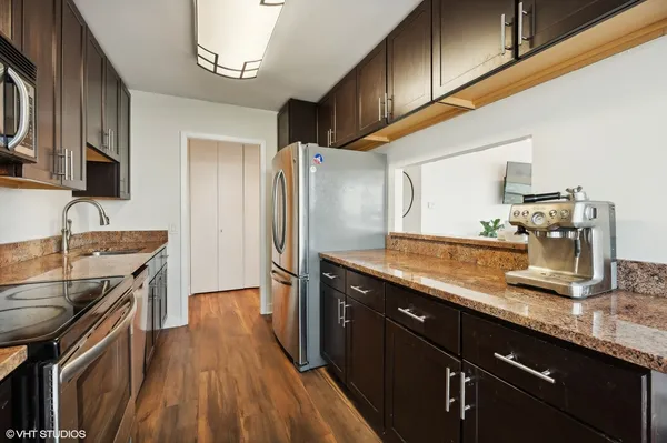 a kitchen with stainless steel appliances granite countertop a sink stove and refrigerator