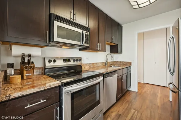 a kitchen with stainless steel appliances wooden cabinets and a stove top oven