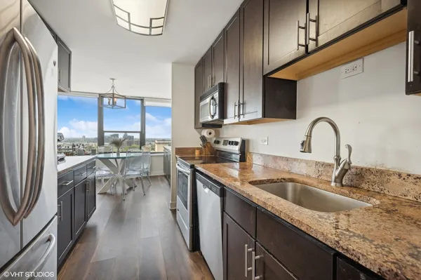 a kitchen with a sink refrigerator and cabinets