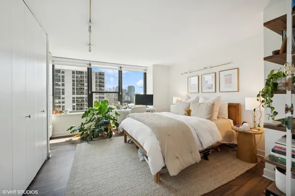 a spacious bedroom with a bed and a potted plant
