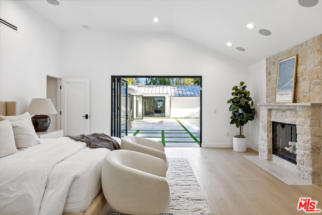 5565 Jed Smith Road Hidden Hills, CA 91302 - Photo 6 of 46 a bedroom with a large bed and a large window